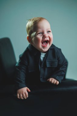 Havalı günlük giysiler içindeki bebek. Küçük şık bir çocuk, 1 yaşında tişörtlü ve beyaz tişörtlü bir çocuk. Bebekler için şık kıyafetler..