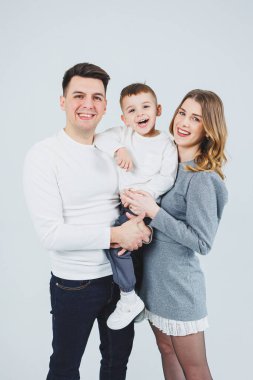 Küçük bir oğlu olan mutlu bir çift. Anne, baba ve gülümseyen oğul. Şık bir aile..