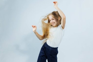 Uzun kıvırcık saçlı, kot pantolonlu beyaz tişörtlü güzel bir kız. Kızın yüzünde farklı duygular var..