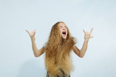 Beyaz tişörtlü ve kot pantolonlu kız portresi beyaz arka planda izole edilmiş. Çocukların duyguları, çocukluk kavramı..