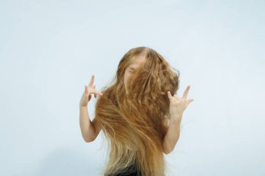 Beyaz tişörtlü ve kot pantolonlu kız portresi beyaz arka planda izole edilmiş. Çocukların duyguları, çocukluk kavramı..