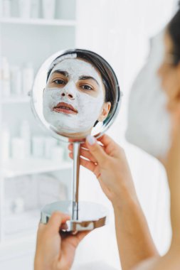 Güzellik salonundaki müşterinizin yüzündeki maske. Cilt temizleme ve nemlendirici konsept. Yüz bakımı.