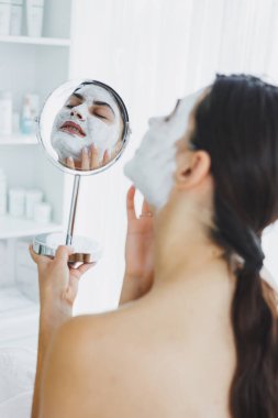 Güzellik salonundaki müşterinizin yüzündeki maske. Cilt temizleme ve nemlendirici konsept. Yüz bakımı.
