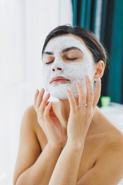 Güzellik salonundaki müşterinizin yüzündeki maske. Cilt temizleme ve nemlendirici konsept. Yüz bakımı.