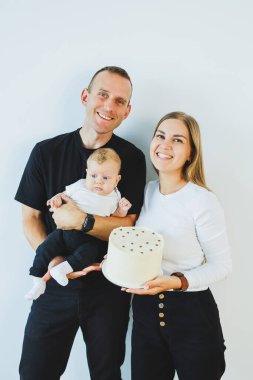 Genç ebeveynler, anne ve baba yeni doğan küçük oğullarını kollarında tutuyorlar. Anne, baba ve yeni doğan bebek evde. Aile ilişkileri. Güzel aile.