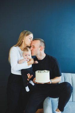 Genç ebeveynler, anne ve baba yeni doğan küçük oğullarını kollarında tutuyorlar. Anne, baba ve yeni doğan bebek evde. Aile ilişkileri. Güzel aile.