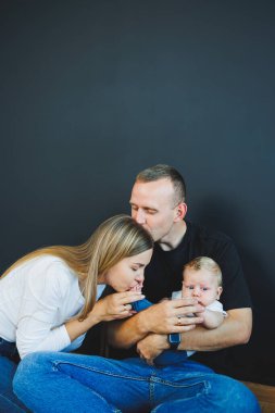 Anne, baba ve yeni doğan oğul evde oynuyorlar. Çocuklu mutlu bir aile..