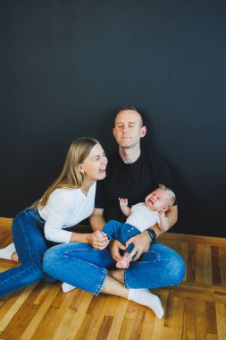 Anne, baba ve yeni doğan oğul evde oynuyorlar. Çocuklu mutlu bir aile..