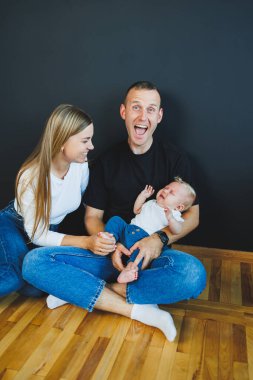 Anne, baba ve yeni doğan oğul evde oynuyorlar. Çocuklu mutlu bir aile..