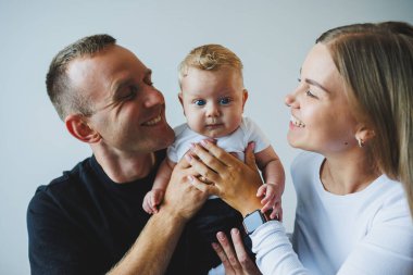 Anne baba kucağında bebek var. Evde mutlu bir aile. Anne, baba ve oğul birlikte oyun oynuyorlar. Bir erkek ve bir kadın, bir çocuğa sevgiyle sarılır..