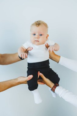 İki aylık bir bebeğin, ailesinin elinde yakın plan çekimleri. Beyaz saçlı, mavi gözlü bir bebek..