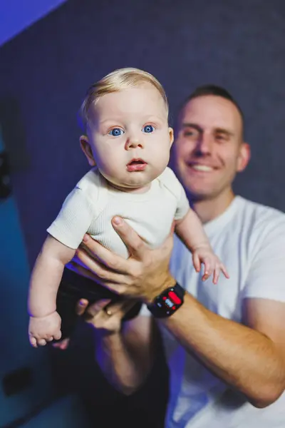 stock image Happy smiling dad is playing with his newborn son. Baby in dad's hands. Smiling child.