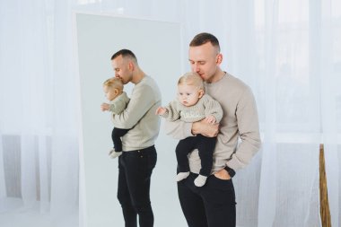 Genç baba yeni doğan oğluna sarılıyor. Baba ve küçük bebek ellerinde. Mutlu bir çocuklu baba..