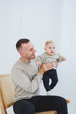 Genç baba yeni doğan oğluna sarılıyor. Baba ve küçük bebek ellerinde. Mutlu bir çocuklu baba..