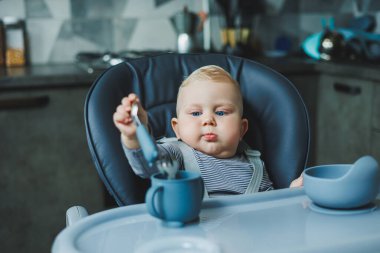Bebek yüksek bir sandalyeye oturur ve silikon tabaklardan yer. Bebekleri beslemek için araçlar.