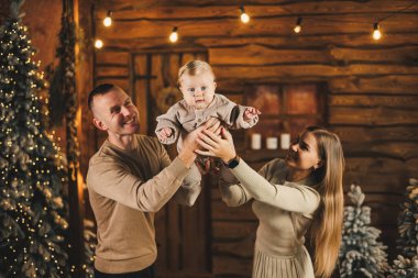 Noel ağacının yanında mutlu bir aile. Genç bir anne ve baba, oğullarını kollarına alıp ona bir şey gösterir. Aile içinde yeni yıl..