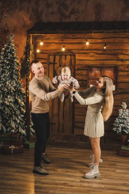 Noel ağacının yanında mutlu bir aile. Genç bir anne ve baba, oğullarını kollarına alıp ona bir şey gösterir. Aile içinde yeni yıl..