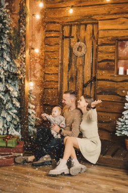 Noel ağacının arkasında çocuklu bir aile. Yeni yıl evinde ellerinde çocuğu olan genç bir adam ve bir kadın. Yeni yılı aile çemberinde kutluyoruz..