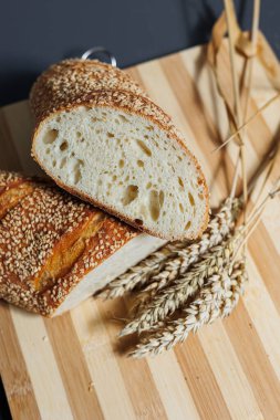 Taze pişmiş çavdar ekmeği mayasız mayalı ekmek ve tam tahıl, çavdar ve buğday unu. Kesik bir tahtanın üzerinde duruyor..