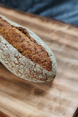 Taze pişmiş çavdar ekmeği mayasız mayalı ekmek ve tam tahıl, çavdar ve buğday unu. Kesik bir tahtanın üzerinde duruyor..
