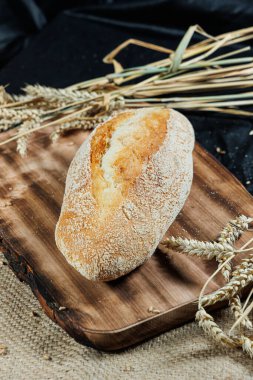 Taze pişmiş çavdar ekmeği mayasız mayalı ekmek ve tam tahıl, çavdar ve buğday unu. Kesik bir tahtanın üzerinde duruyor..