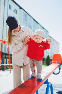 Bir anne küçük oğluna akor çalmayı öğretir. Bebeğin ilk adımları.