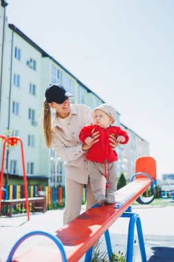 Bir anne küçük oğluna akor çalmayı öğretir. Bebeğin ilk adımları.