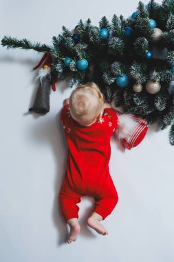 Bebek, Noel ağacının yanında yatıyor. Çocukların ilk Noel 'i. Küçük bir çocuk Noel 'i kutluyor. Yeni yıl tatili. Noel Baba ağacı olan çocuk. Noel Baba bebek.