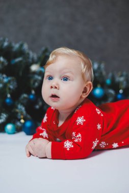 Bebek, Noel ağacının yanında yatıyor. Çocukların ilk Noel 'i. Küçük bir çocuk Noel 'i kutluyor. Yeni yıl tatili. Noel Baba ağacı olan çocuk. Noel Baba bebek.