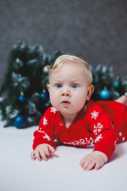 Bebek, Noel ağacının yanında yatıyor. Çocukların ilk Noel 'i. Küçük bir çocuk Noel 'i kutluyor. Yeni yıl tatili. Noel Baba ağacı olan çocuk. Noel Baba bebek.