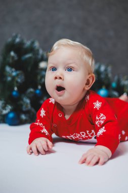 Bebek, Noel ağacının yanında yatıyor. Çocukların ilk Noel 'i. Küçük bir çocuk Noel 'i kutluyor. Yeni yıl tatili. Noel Baba ağacı olan çocuk. Noel Baba bebek.