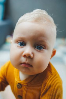 Mutlu gülümseyen çocuk. Gülümseyen yüzüyle yeni doğmuş şirin bir erkek bebek yerde sürünüyor. Annelik bebek bakımı konsepti Mutlu bebek