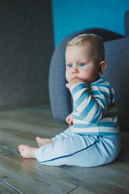 Mutlu gülümseyen çocuk. Gülümseyen yüzüyle yeni doğmuş şirin bir erkek bebek yerde sürünüyor. Annelik bebek bakımı konsepti Mutlu bebek