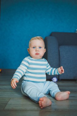 Mutlu gülümseyen çocuk. Gülümseyen yüzüyle yeni doğmuş şirin bir erkek bebek yerde sürünüyor. Annelik bebek bakımı konsepti Mutlu bebek