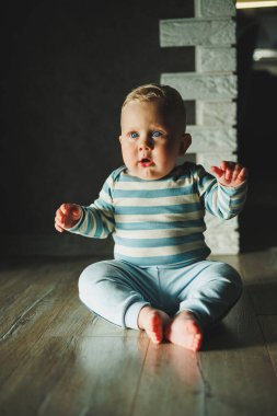 Mutlu gülümseyen çocuk. Gülümseyen yüzüyle yeni doğmuş şirin bir erkek bebek yerde sürünüyor. Annelik bebek bakımı konsepti Mutlu bebek