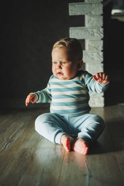 Mutlu gülümseyen çocuk. Gülümseyen yüzüyle yeni doğmuş şirin bir erkek bebek yerde sürünüyor. Annelik bebek bakımı konsepti Mutlu bebek