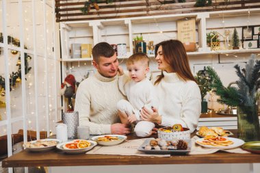 Mutlu bir aile ve oğulları mutfakta yeni yıl yemeği hazırlıyorlar. Noel sabahı mutfakta bir çocukla aile kahvaltısı..