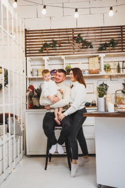 Mutlu bir aile ve oğulları mutfakta yeni yıl yemeği hazırlıyorlar. Noel sabahı mutfakta bir çocukla aile kahvaltısı..