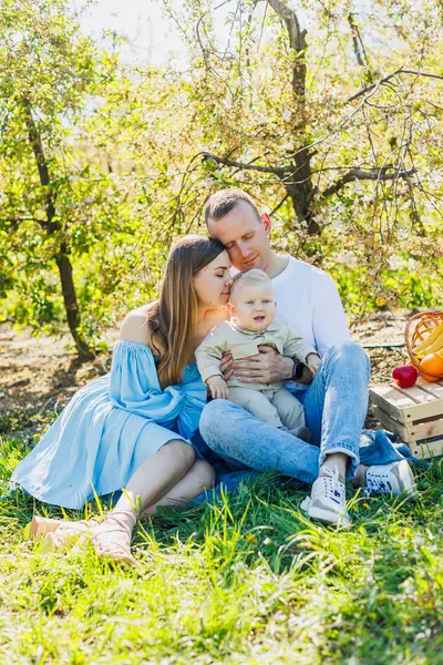 Baba ve anne küçük oğlunu doğada tutuyor, güzel aile bağları kavramı. Küçük bir oğlu olan ebeveynlerin aile fotoğrafı. Mutlu aile kavramı.