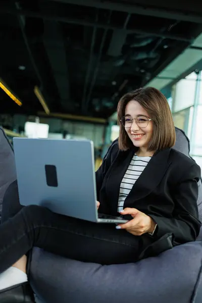 stock image Smiling business woman, company employee, working holding laptop while sitting in modern office. Modern business woman working online.