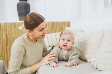 Genç bir anne yeni doğan oğluna sarılır. Anne ve küçük çocuk ellerinde. Mutlu çocuklu anne..