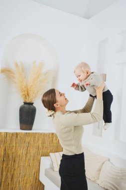 Genç bir anne yeni doğan oğluna sarılır. Anne ve küçük çocuk ellerinde. Mutlu çocuklu anne..