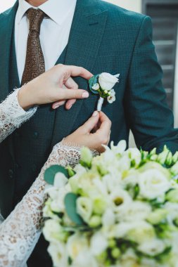 Yeni evlilerin ellerinin yakın çekimi. Bir erkek bir kadının elini tutar..