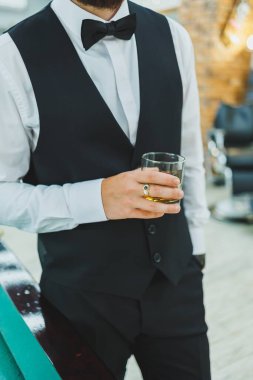 Klasik takım elbiseli bir adam ve bir bardak viski. Erkekler için içecekler.