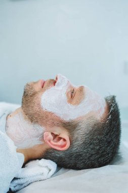 Adam dermatologla randevuda. Erkek kozmetolojisi. Kozmetik kliniğindeki erkekler için maskeler.