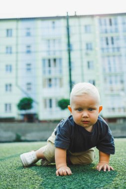Yeşil çimlerin üzerinde yatan tatlı çocuk. Çocuğun dışarıdaki aktif zamanı. Yazın sokakta koşan bir çocuk..