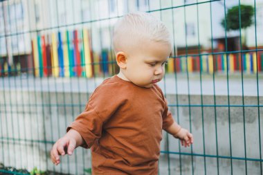 Futbol sahasında koşan tatlı çocuk. Çocuğun dışarıdaki aktif zamanı. Yazın sokakta bir çocuk koşar. Kotlu ve tişörtlü bir çocuk. Şık bir çocuk.