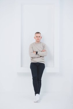 Beyaz arka planda bir adam siyah ve paçavra pantolon giyiyor. Erkek kıyafetleri..