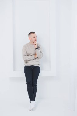 Beyaz arka planda bir adam siyah ve paçavra pantolon giyiyor. Erkek kıyafetleri..