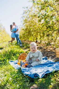 Bebek dışarıda yeşil çimlerin üzerinde oturuyor. Ailesinin geçmişine karşı bir çocuk..